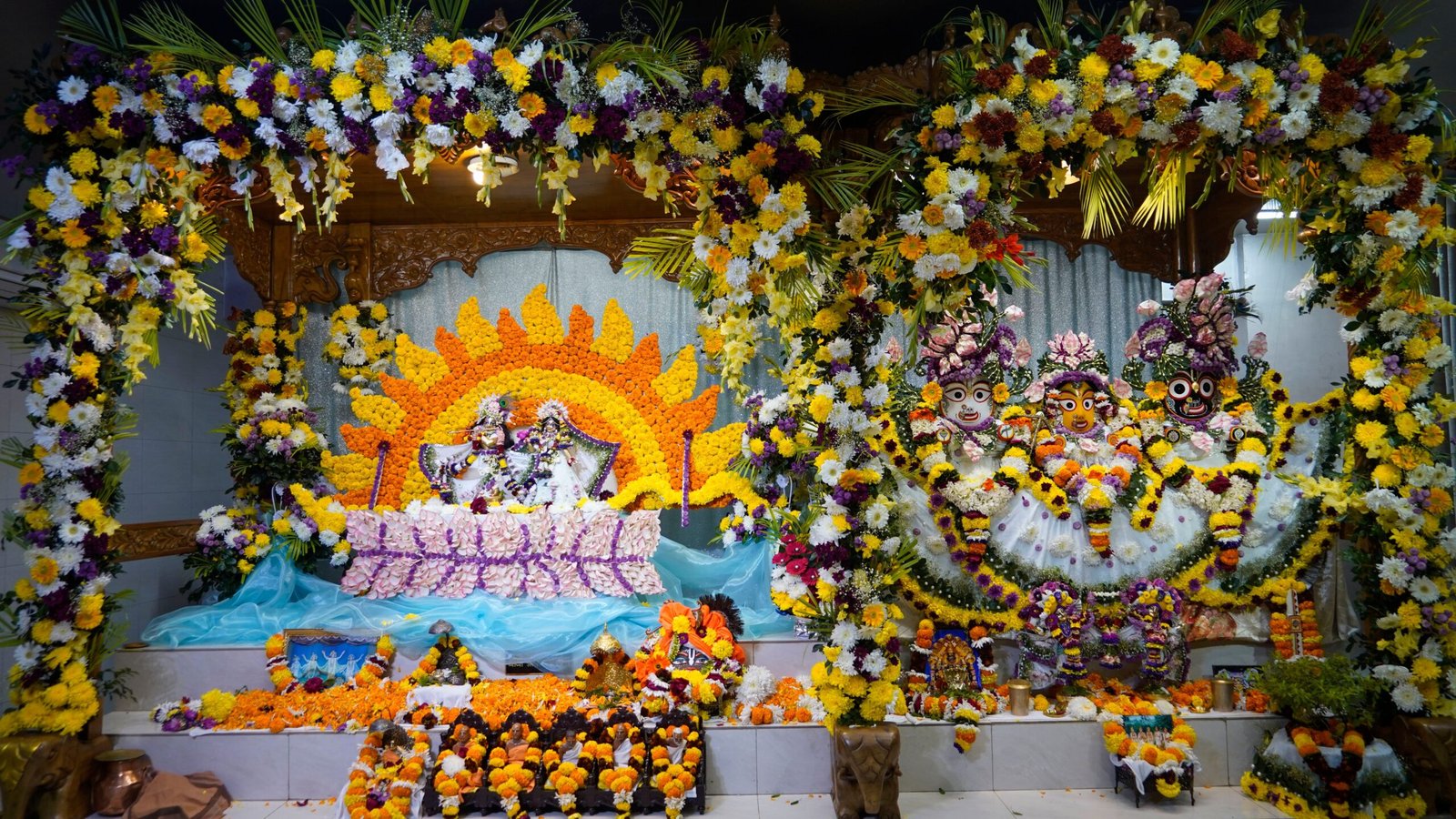 A colorful Hindu altar adorned with vibrant flowers and religious figures for worship.