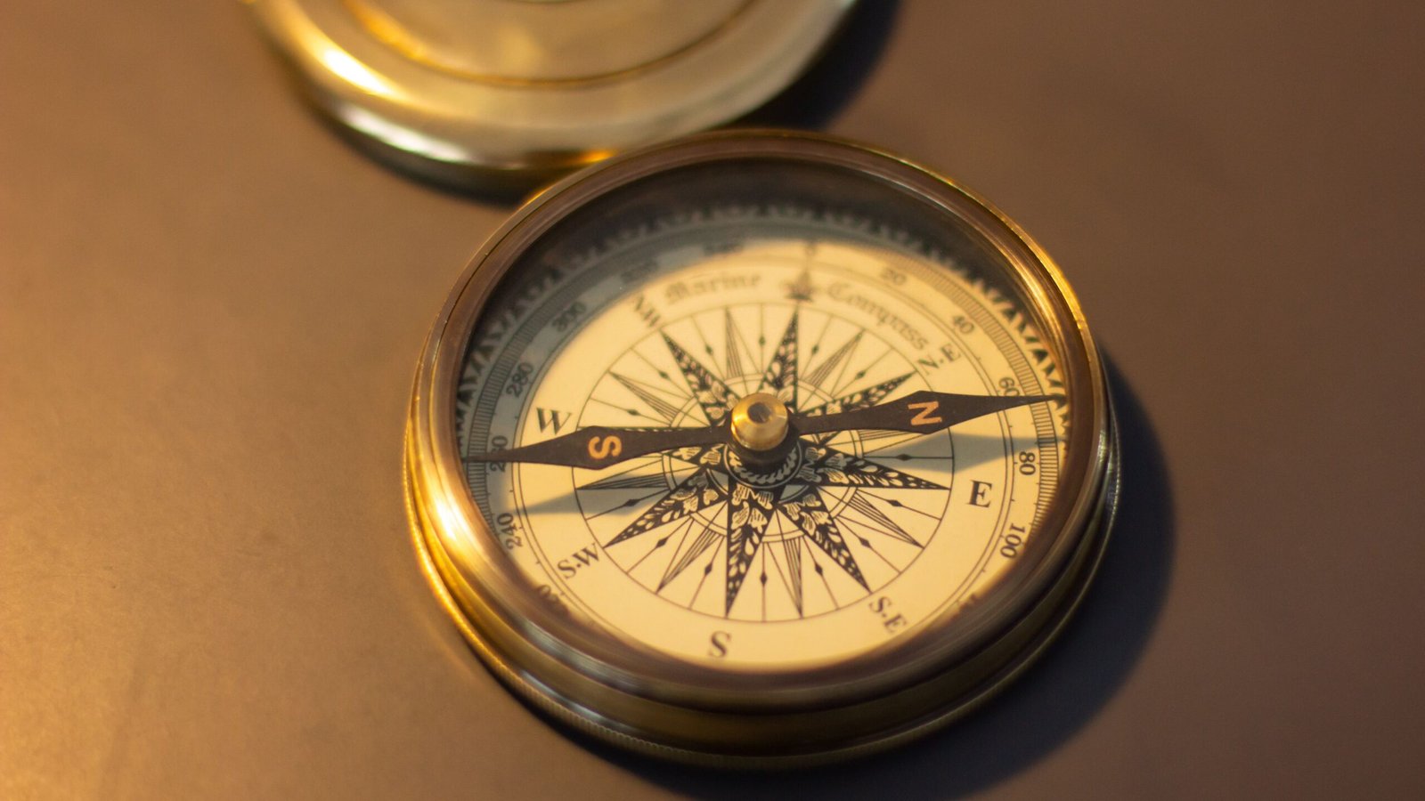 Close-up of a vintage brass compass, emphasizing its nautical design and retro charm.